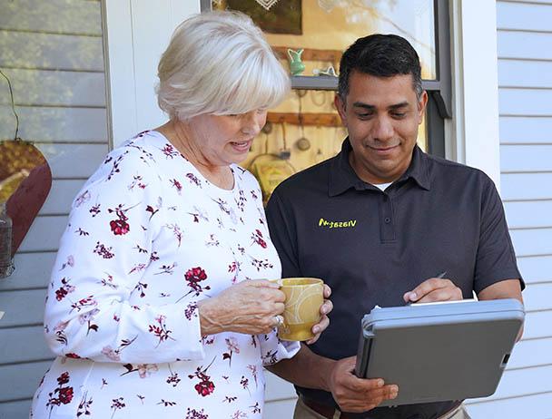 hg皇冠官网 technician talking to a woman in front of her house