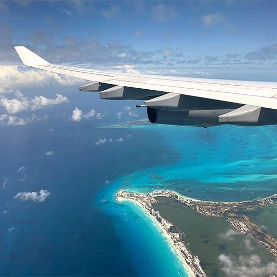 A commercial jet flying over the ocean, connected by Viasat satellite internet