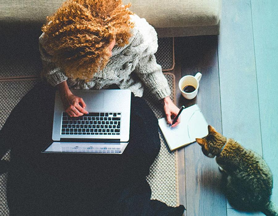 A girl at home, working on her laptop connected by Viasat satellite internet